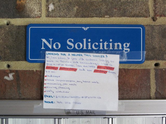 A sign says No Soliciting with a note attached to it that is soliciting.